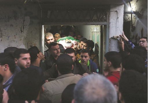 Palestinian mourners carry the body of Mohamed Abu Zaida, who died after being shot in the neck by Israeli security forces at a protest, during his funeral in the Bureij refugee camp in central Gaza yesterday.