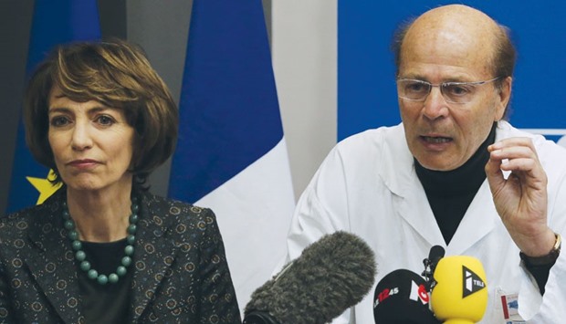 Minister Touraine listens as Gilles Hedan, professor of clinical  neurology, explains at a news conference in Rennes, France on the case of the clinical trial that has left one person brain dead and five others are in a serious condition.