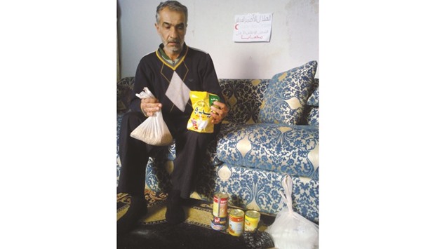 A Madaya resident receiving a food pack donated by QRCS.