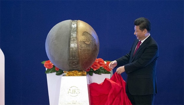 Chinese President Xi Jinping (C) unveils a sculpture during the opening ceremony of the Asian Infras