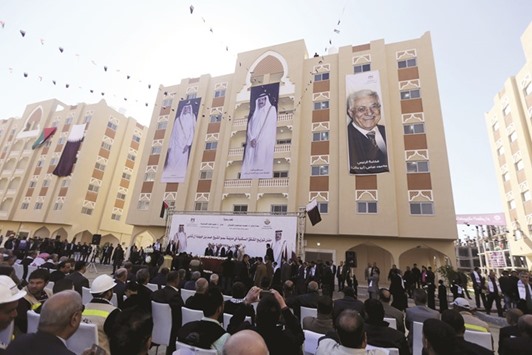 Posters depicting HH the Father Emir Sheikh Hamad bin Khalifa al-Thani,  HH the Emir Sheikh Tamim bin Hamad al-Thani and Palestinian President Mahmoud Abbas are seen on a building as people attend the opening ceremony of Qatari-funded construction project u201dHamad Cityu201d, in Khan Younis in the southern Gaza Strip yesterday.
