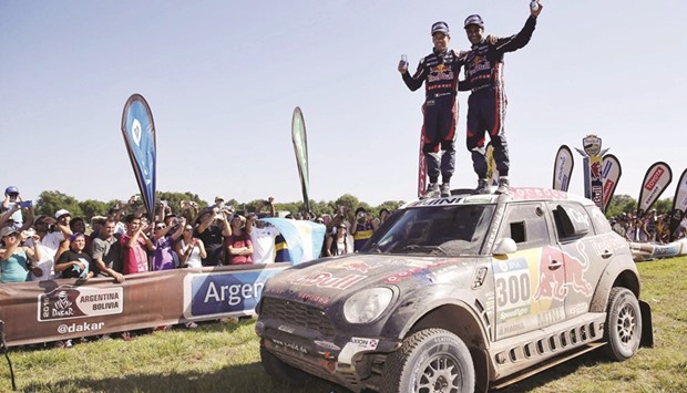 Qataru2019s Nasser Al-Attiyah (right) and co-driver Baumel Matthieu of France wave from the top of their Mini at the end of the 13th and final stage of the Dakar Rally 2016 in Rio Cuarto, Argentina. (Reuters)