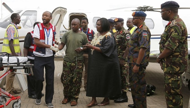 A wounded Kenyan soldier (C) serving in the African Union Mission in Somalia (AMISOM) is received by military officers and paramedics at the Wilson airport in Kenya's capital Nairobi.