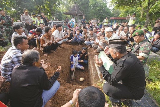 Mourners and relatives pray over the grave of terror attack victim Rico Hermawan during a funeral secured by armed police commandos at a cemetery in Boyolali, Indonesiau2019s central Java island yesterday.