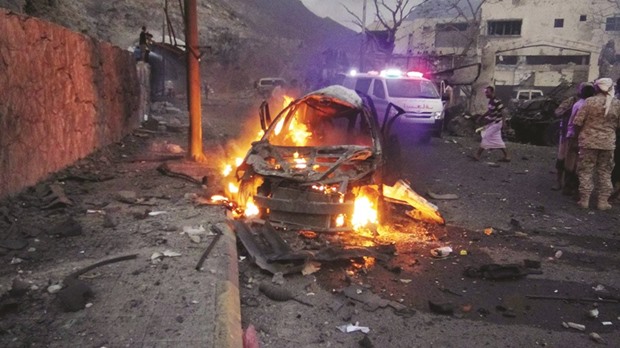 A car burns at the site of a bomb attack outside the house of the director of security for Aden, General Shalal Shaea, yesterday.