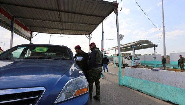 Iraqi security forces inspect a car at a checkpoint on the main road from Baghdad's central Jaderiyah district to Dora on the southern outskirts of the Iraqi capital.  US and Iraqi authorities were searching for three missing Americans said to have been kidnapped in southern Baghdad. AFP
