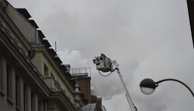 Firefighters work on extinguishing a fire at the Ritz Hotel in Paris
