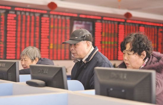 Investors look at computer screens showing stock information at a brokerage house in Fuyang, Anhui province. Chinau2019s stocks rebounded 3.2% yesterday.