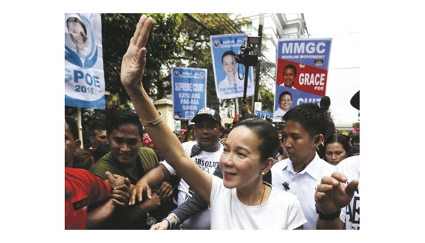 Senator and presidential candidate Grace Poe waves to supporters as she walks towards the Supreme Court to attend the oral arguments on the Commission on Elections (Comelec) disqualification cases filed against her for the forthcoming May elections, in Manila.