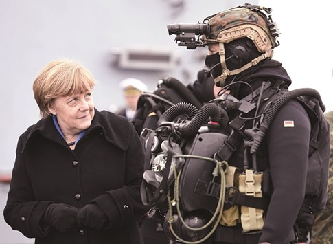 German Chancellor Angela Merkel looks at a combat diver during her visit to Naval Base Command in Kiel yesterday.