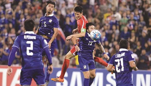 North Korean and Thailand players vie for the ball during their final Group B league match at the AFC U-23 Championship yesterday at the Grand Hamad Stadium in Doha yesterday. Below: Thailand fans celebrate their teamu2019s goal. PICTURES: Mamdouh