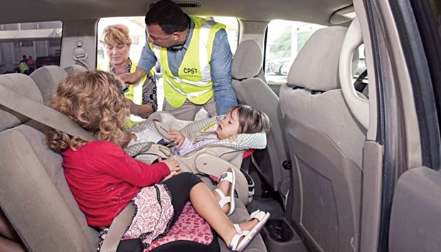 A CPST technician explains the method to install child car seats and for positioning children correctly in the seats.