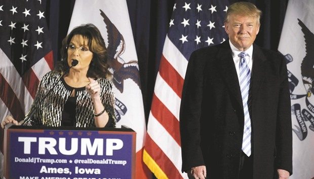 Republican presidential candidate Donald Trump smiles as former Alaska governor Sarah Palin endorses him at a rally at Iowa State University in Ames, Iowa.