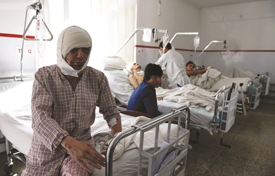 A wounded staff member of Moby Media Group sits on a bed during his treatment in Kabul yesterday.