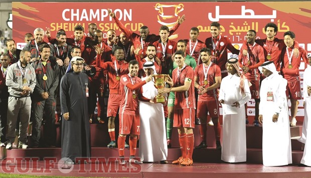 Lekhwiya captain Karim Boudaif (12) and Khalid Muftah (77) receive the Sheikh Jassim Cup from Qatar Football Association president Sheikh Hamad bin Khalifa bin Ahmed al-Thani after their 4-1 victory over Al Sadd yesterday. Pictures: Noushad Thekkayil
