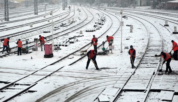 Workers remove snow from railways at a train station in Nanchang in Chinau2019s Jiangxi province.