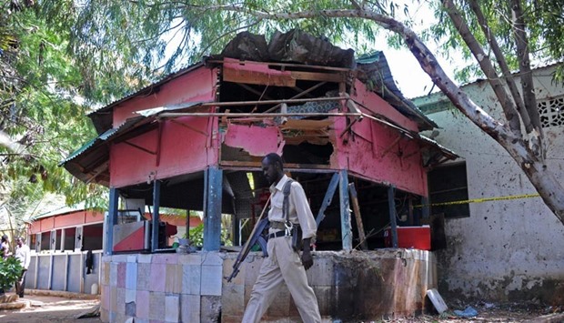 A Somalia policeman walks at the scene of an explosion at the Village Restaurant in Mogadishu, on Saturday.