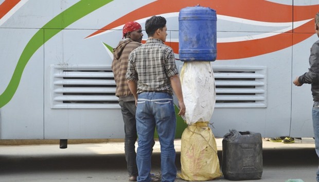 Men in Nepalu2019s capital, Kathmandu, unload fuel smuggled over the border from India on a bus this month.