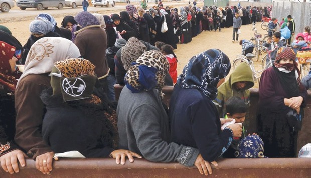 Syrian refugees stand in line as they wait for aid packages at Al Zaatari refugee camp in the Jordanian city of Mafraq, near the border with Syria, on Wednesday.