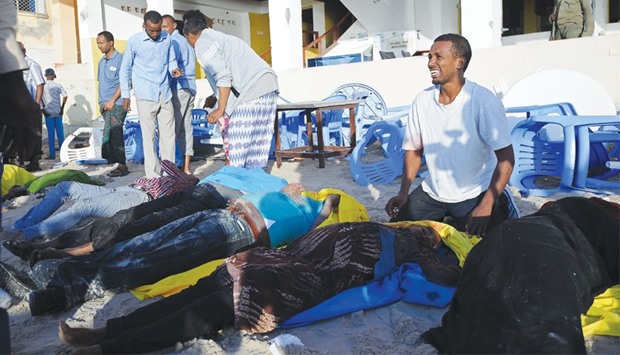 A man cries next to bodies on the Lido beach yesterday following an overnight attack on a beachfront restaurant in Mogadishu.