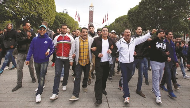 Unemployed graduates shout slogans during a demonstration to demand the government provide them with job opportunities, on Habib Bourguiba Avenue in Tunis, Tunisia yesterday.
