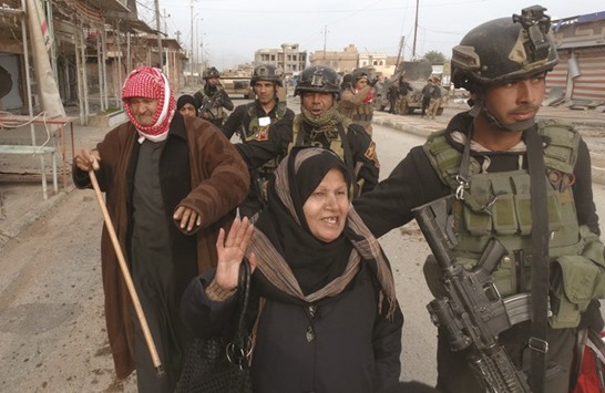 Civilians flee to a safe area with help from Iraqi security forces in Ramadi city, on December 31, 2015.