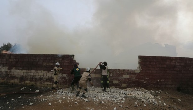 Civil defence members try to put out a fire after what activists said were airstrikes carried out by the Russian air force in the town of Sarmada. Reuters