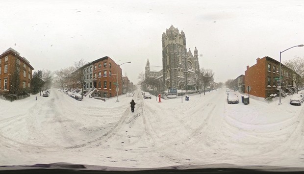 In this image created as an equirectangular panorama, a person walks in blizzard-like conditions yesterday in the Brooklyn borough of New York City.