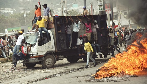Demonstrators pass burning tyres during a protest in Port-au-Prince on Friday.