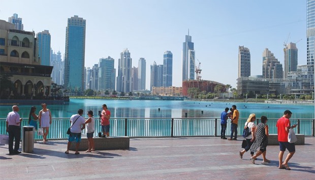 Residential and commercial skyscrapers dot the city skyline as visitors walk through the downtown district in Dubai. Dubaiu2019s property market was buffeted last year by falling oil prices, rising political tension in the region and slowing  economic growth from China to Brazil: All trends that are set to continue in 2016.