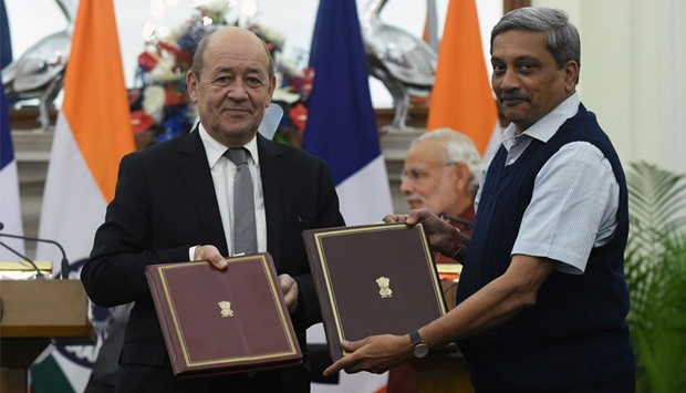 French Defence Minister Jean-Yves Le Drian (L) and his Indian counterpart Manohar Parrikar show off the intergovernmental agreements for the purchase of 36 Rafale jet fighters at a joint press conference in New Delhi. AFP