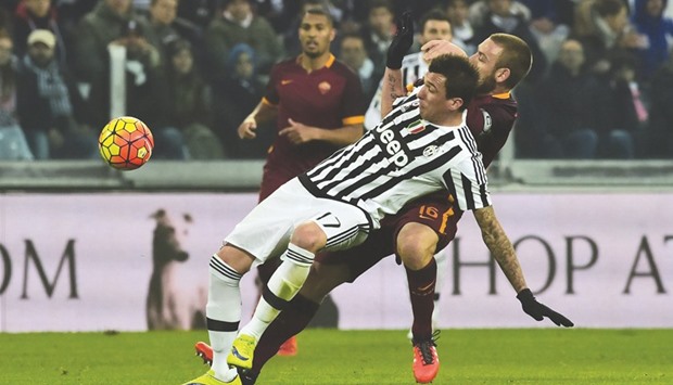 Romau2019s Daniele De Rossi (back) fights for the ball with Juventusu2019 Mario Mandzukic during the Italian Serie A football match at Juventus Stadium in Turin on Sunday. (AFP)