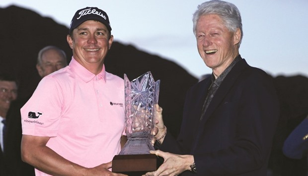 Jason Dufner (left) is presented with the trophy by former United States president Bill Clinton after winning the CareerBuilder Challenge in partnership with the Clinton Foundation, at the TPC Stadium course in La Quinta, California, on Sunday. (AFP)