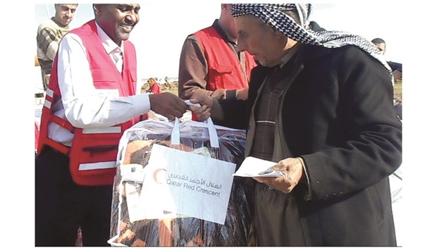 QRCS officials distributing relief items in Al-Anbar governorate.