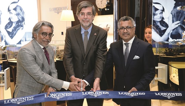 Swiss ambassador Etienne Thu00e9voz (centre) and The Rivoli Group managing partner Ramesh Prabhakar (left) open the Longines boutique as another official looks on.  PICTURE: Thajudheen