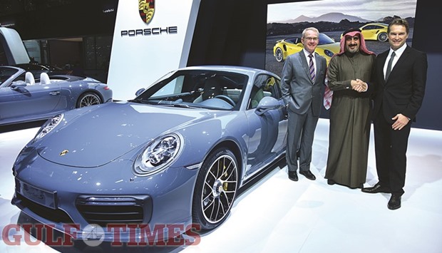 Deesch Papke, Porsche Centre Doha chairman and CEO Salman Jassem al-Darwish and another official present a new vehicle yesterday.