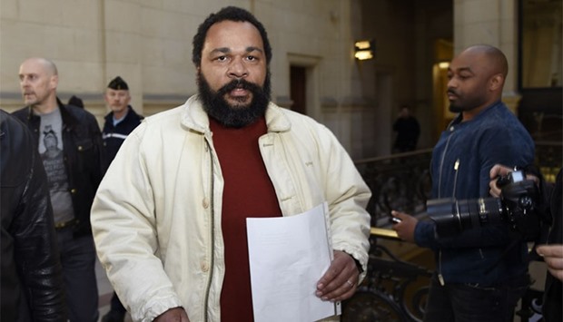 This file picture taken on March 12, 2015 shows French controversial comic Dieudonne M'bala M'bala (C) arriving at the Paris courthouse.  AFP