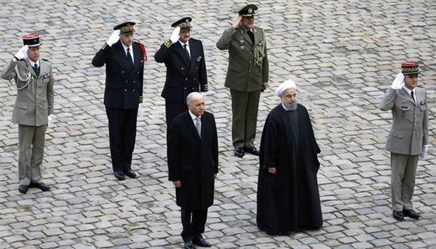 French Foreign Affairs Minister Laurent Fabius (L) and Iran's President Hassan Rouhani attend a ceremony in the courtyard of the Hotel des Invalides in Paris, France. Reuters