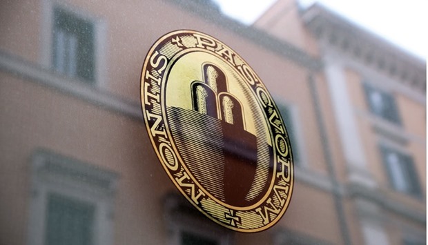 The Banca Monte dei Paschi logo sits on a window at one of the companyu2019s branches in Rome on Wednesday. The troubled lender spearheaded the decline in Italian banking shares yesterday, slumping 9.81%.
