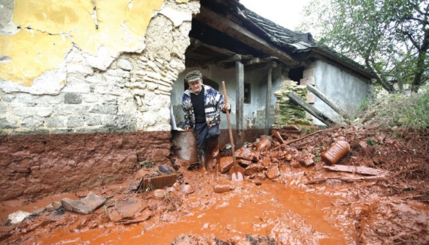 This October 6, 2010 file picture shows a man trying to clean up his house in the village of Devecser, Hungary, which had been hit by toxic sludge.