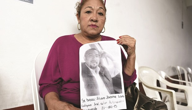 The mother of one of the five youngsters who went missing shows a picture of her son as she camps at the public prosecutoru2019s office in Tierra Blanca community, Veracruz state, Mexico.