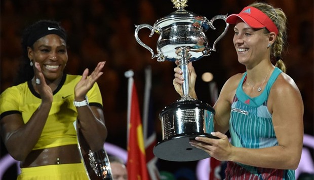 Germany's Angelique Kerber (R) holds The Daphne Akhurst Memorial Cup as she celebrates after victory in her women's singles final match against Serena Williams of the US (L) on day thirteen of the 2016 Australian Open tennis tournament in Melbourne.