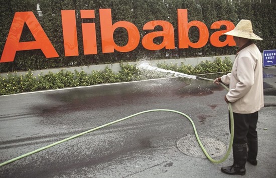 A cleaner waters flowers below a logo of Alibaba at the companyu2019s headquarters on the outskirts of Hangzhou, Zhejiang province. The Chinese e-commerce giant beat analyst estimates for revenue and profit, traditionally the primary metrics by which a companyu2019s performance is measured.