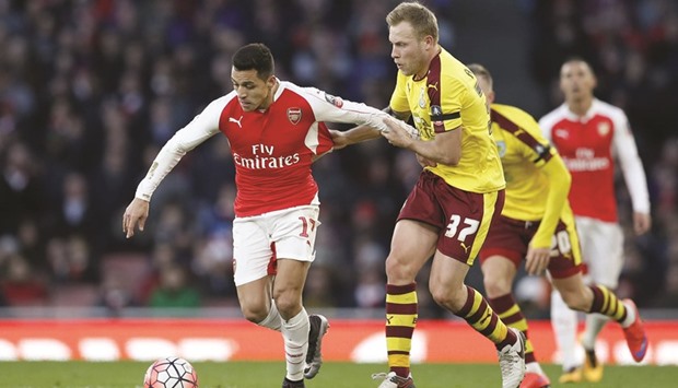 Arsenalu2019s Alexis Sanchez gets past Burnleyu2019s Scott Arfield during the FA Cup Fourth Round match at the Emirates Stadium in London yesterday. (Reuters)