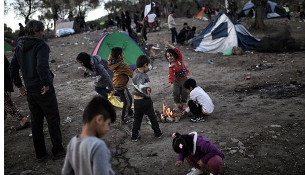 This file photo taken on November 4, 2015 shows refugee and migrant children, living in a field next door to the Moria camp on the Greek island of Lesbos, wait to be registered in Mytilene.  AFP