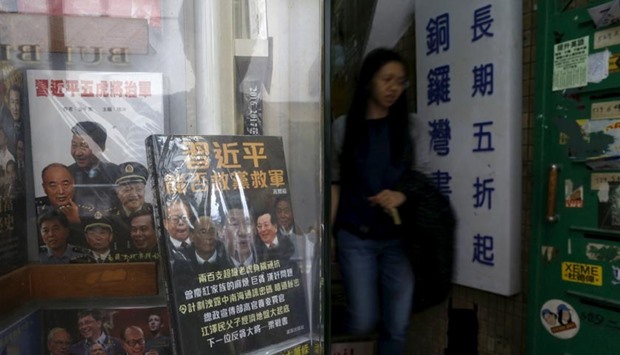 A woman walks past a display cabinet of Causeway Bay Books displaying books critical of the Chinese leadership, in Hong Kong.