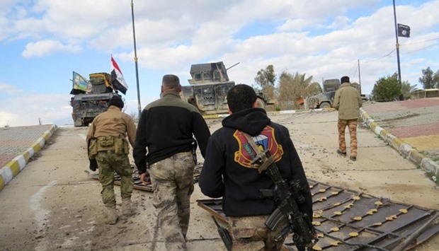Iraqi pro-government forces walk towards military vehicles during battles with Islamic State  jihadists as they try to secure all the neighbourhoods of Ramadi on Sunday.