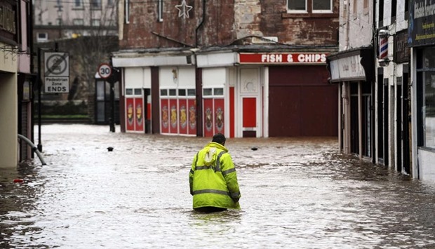 A man wades through floodwater in a street in Dumfries, southern Scotland, last week after heavy rainfall brought by Storm Frank