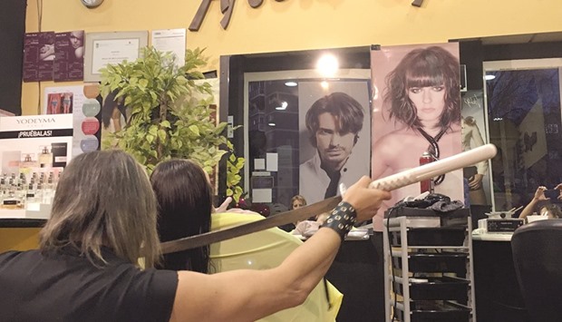 THE ARTIST: Alberto Olmedo, 51, layers customer Olgau2019s hair with a sword in his Madrid salon. The Spanish stylist prefers swords to scissors to cut hair u2014 sometimes one, sometimes two at once, kneeling on the ground as he brandishes them.