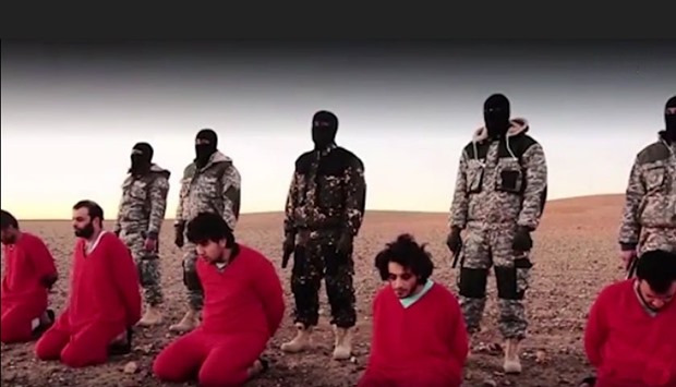 The video shows the five wearing orange jumpsuits and kneeling before five masked fighters, all in military fatigues and armed with pistols. 